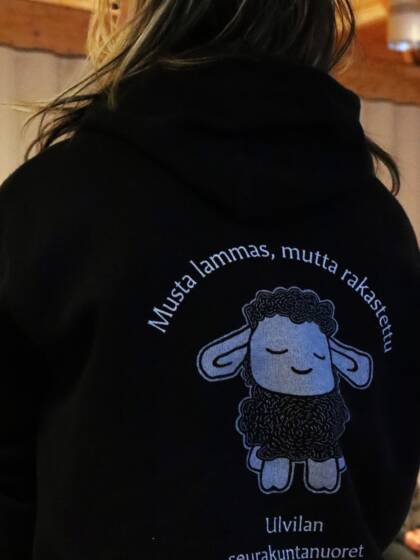 musta huppari, jossa selässä lampaan kuva ja teksti musta lammas mutta rakastettu, ulvilan seurakunta