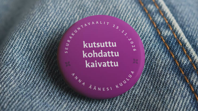 Violetti rintamerkki farkkukankaalla, teksti "kutsuttu, kohdattu, kaivattu" ja päivämäärä "15.11.2026".